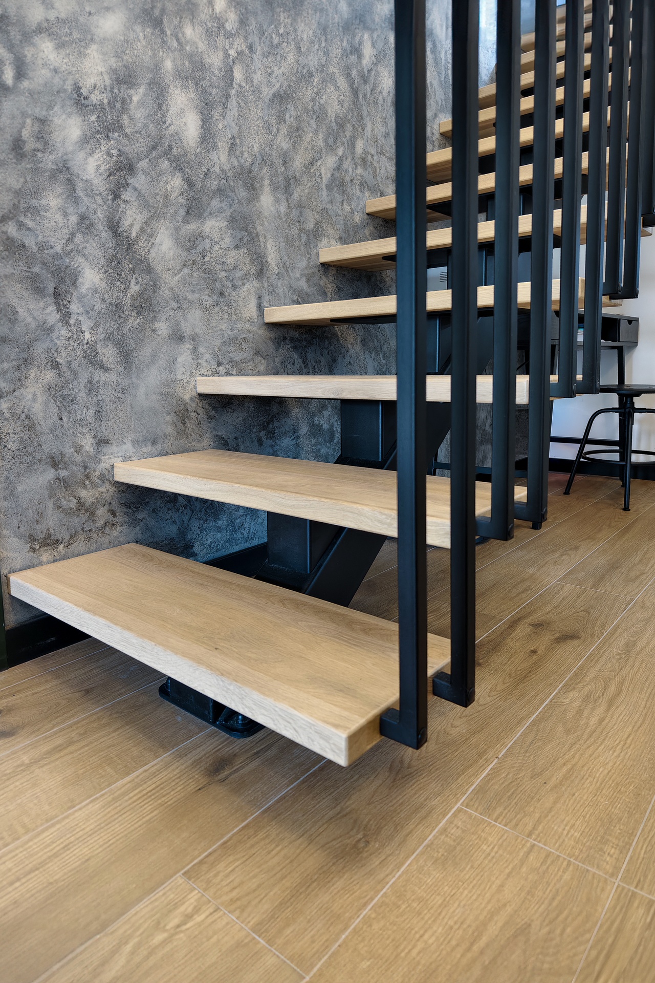 detal stopnie drewniane i czarna balustrada harfa