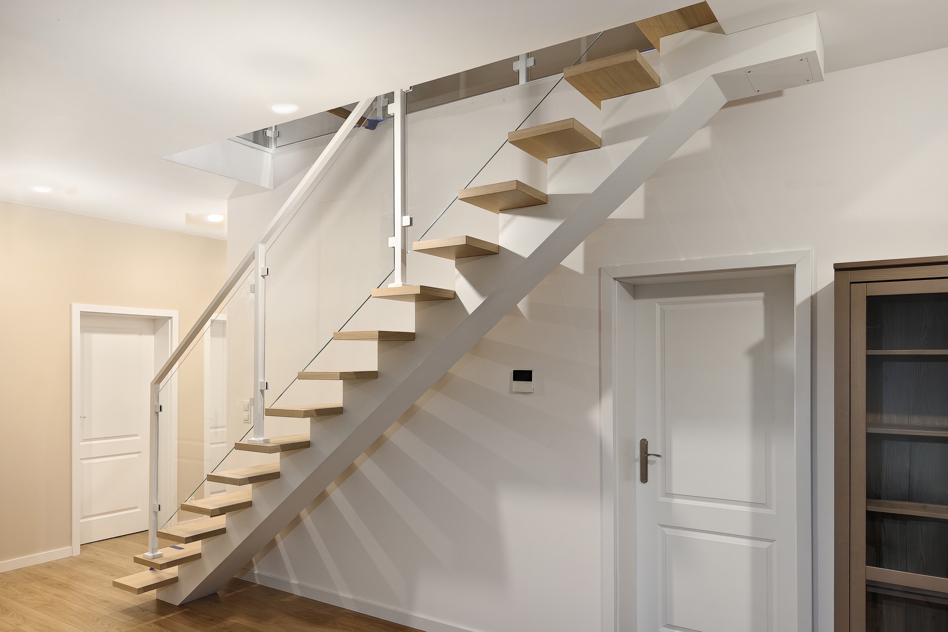 schody loftowe biale z balustrada szklana w salonie